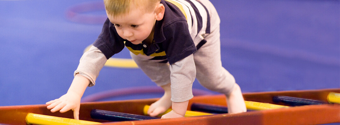 Child playing in community centre equipped with specialized flooring