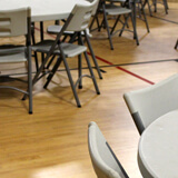 Plancher sportif Omnisports Speed dans une caféteria/gymnase avec chaises et tables