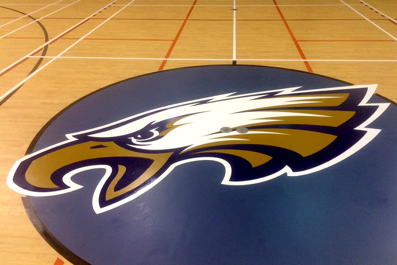 Eagle logo in the centre circle of a school gymnasium