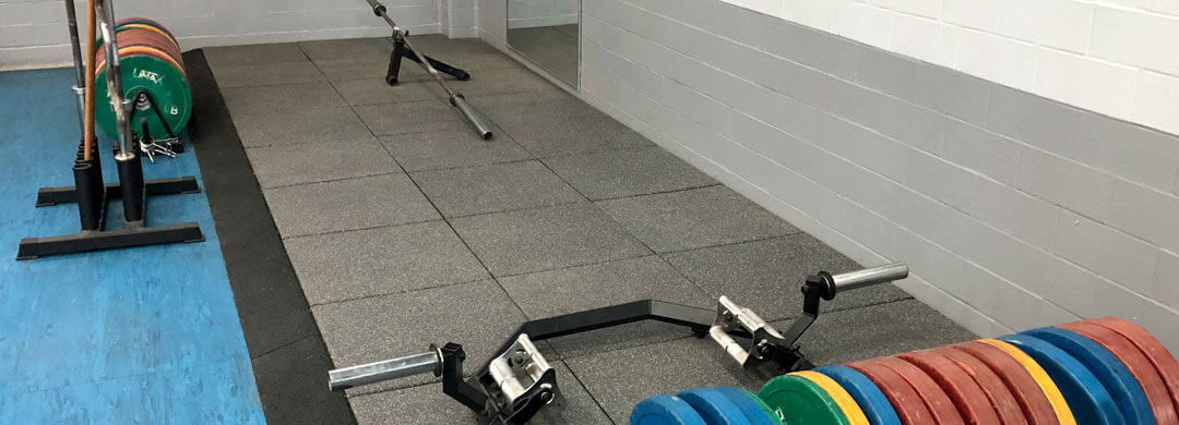 Plancher dans un gym en tuiles de caoutchouc pour les poids lourds