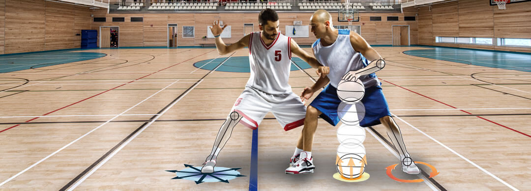 Two men playing basketball in gymnasium