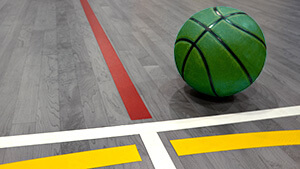 Ballon de basketball vert sur un revêtement de plancher sportif