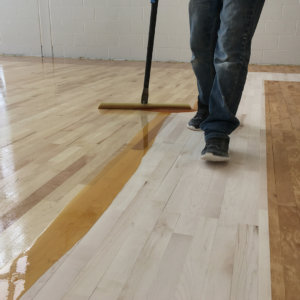 Installer sealing the hardwood floor