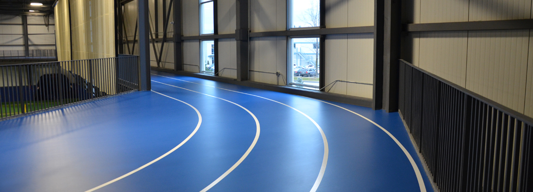 Piste de course avec revêtement de sol résilient installé dans un complexe sportif canadien
