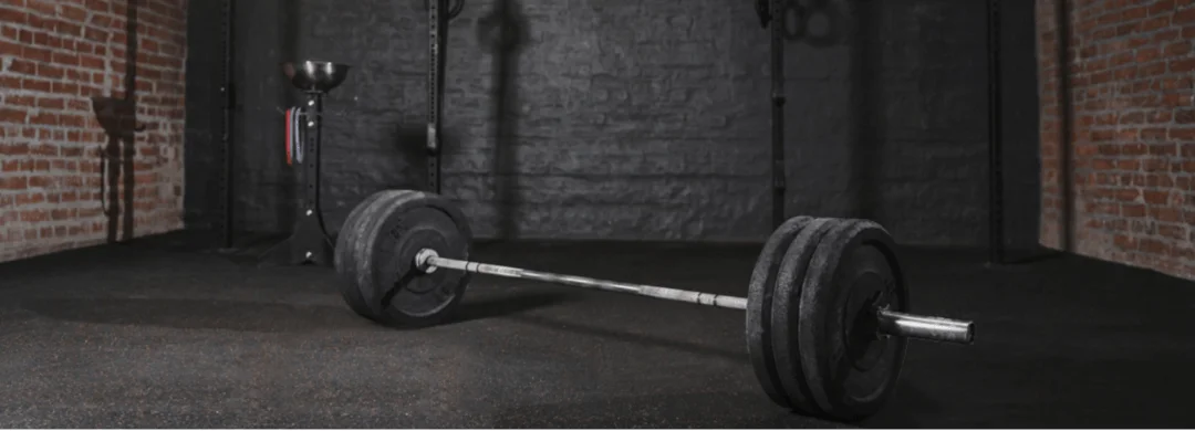 Barre d'haltères sur un plancher en caoutchouc dans un centre d’entraînement physique