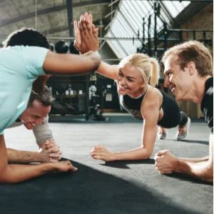 Groupe de quatre athlètes s'entraînant sur un plancher en caoutchouc