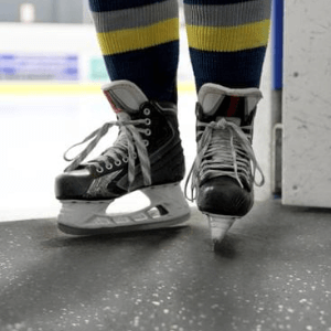 Joueur de hockey avec des patins sur un revêtement de sol en caoutchouc.